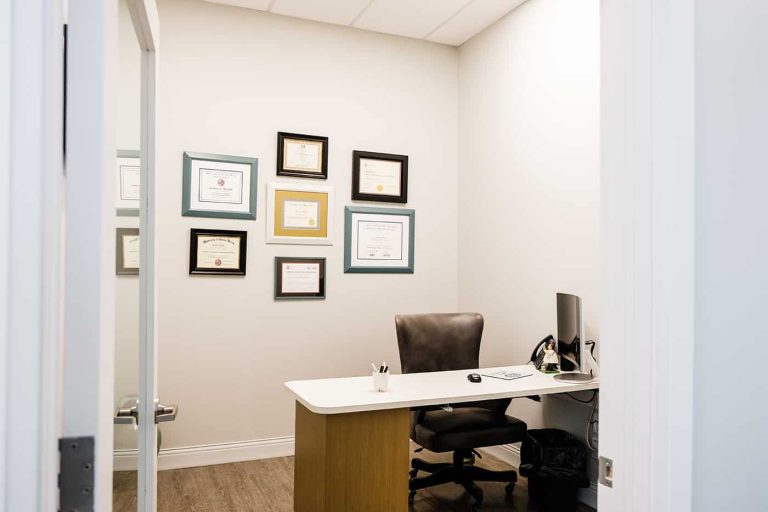 A office with framed degrees hanging on the wall.